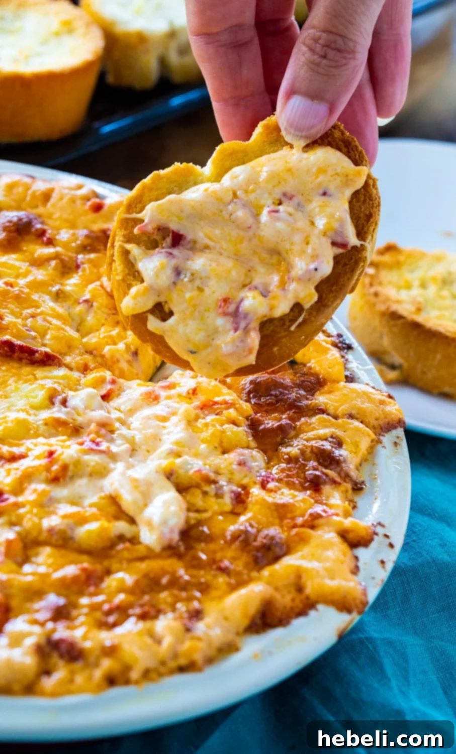 Bubbly Baked Pimento Cheese Dip 4 Slice of baguette expertly scooping up a generous portion of warm, cheesy pimento dip.