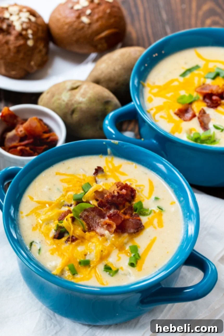 A close-up of a loaded Baked Potato Soup, overflowing with melty cheese, crispy bacon, and vibrant green onions.