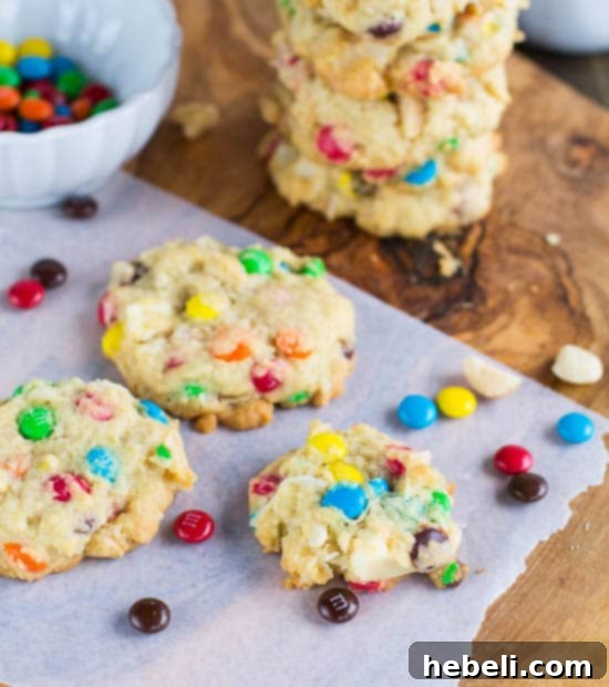 M&M, Coconut, and Macadamia Cookies arranged artfully on a white plate with a rustic background