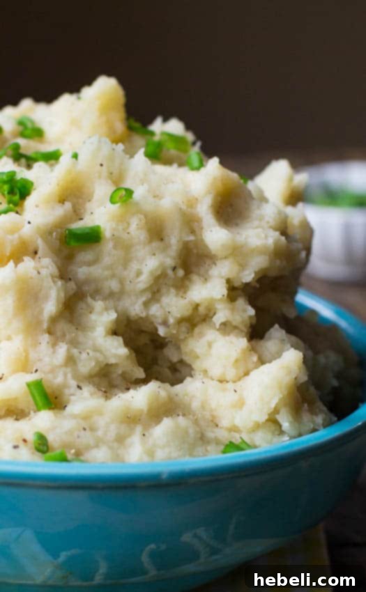 A final presentation of incredibly smooth and creamy Slow Cooker Mashed Potatoes, garnished simply for an elegant touch.
