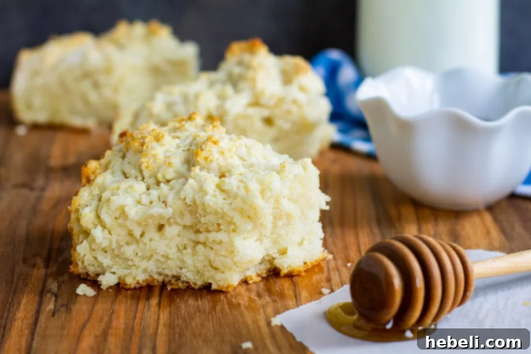 Several large Cat Head Biscuits arranged on a rustic wooden board, ready to be served.