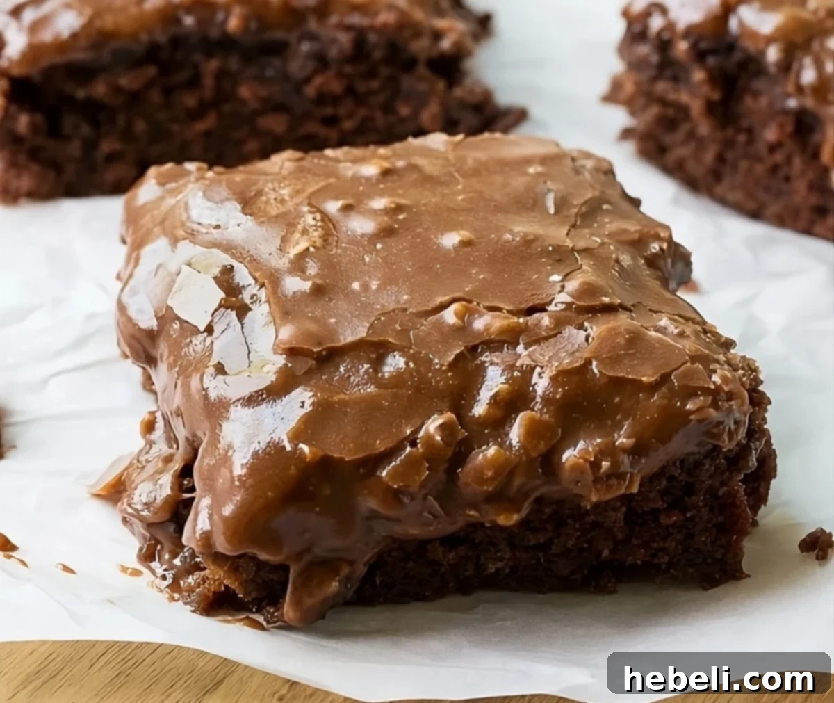 Velvety Chocolate Buttermilk Indulgence 2 A perfectly square slice of chocolate buttermilk cake, showcasing its rich texture and fudgy frosting, resting on parchment paper.