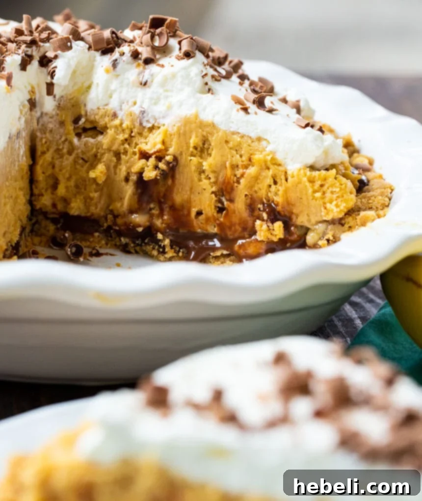 Close-up of Creamy Peanut Butter Banana Pie in a white pie pan, showing the thick fudge layer under the peanut butter filling.