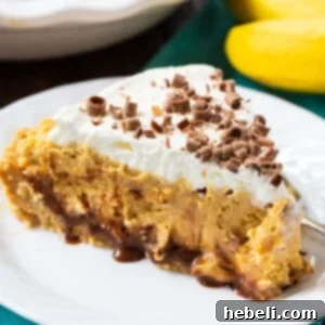 Slice of Peanut Butter Banana Pie on a white plate, ready to be enjoyed.