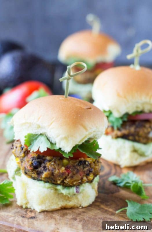 Three delicious Baked Pumpkin-Black Bean Sliders with fresh Avocado Sauce, cilantro, and tomato slices