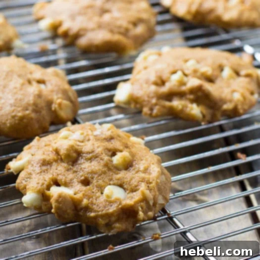 Decadent Pumpkin White Chocolate Chip Cookies 3 Pumpkin-White Chocolate Chip Cookies arranged on a cooling rack
