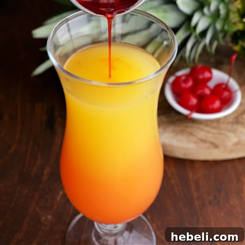 Inverted Aloha 6 Grenadine being slowly poured into the cocktail glass to create layers.