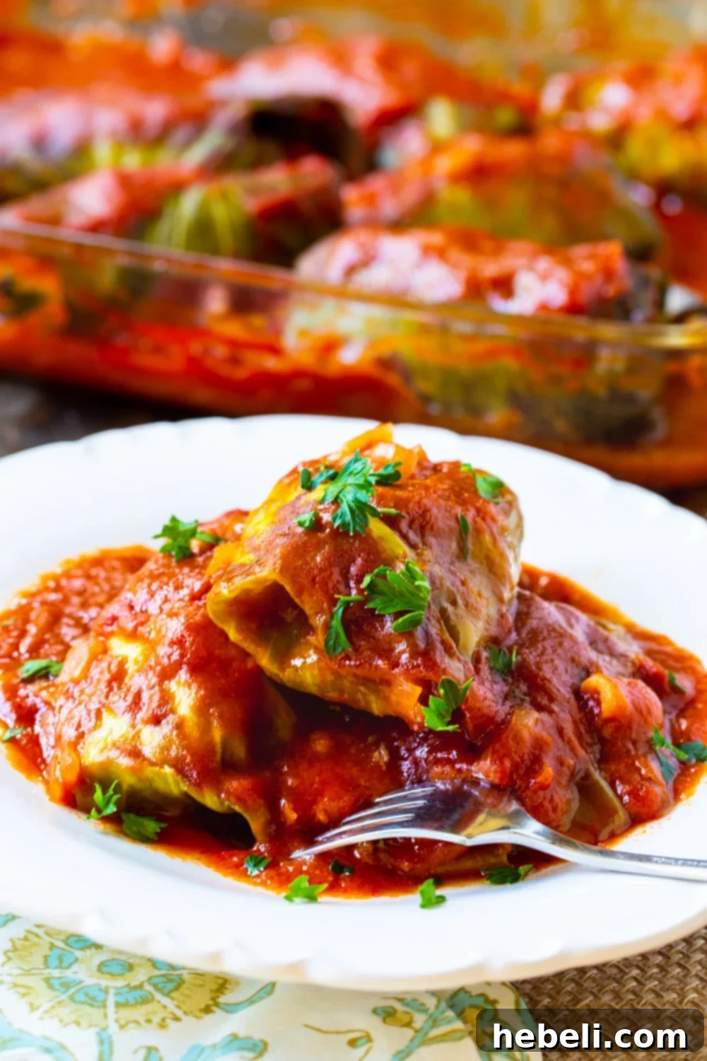 Savory Stuffed Cabbage Rolls 3 Stuffed Cabbage Rolls served on a plate with a fork, showing the rich tomato sauce and tender cabbage.
