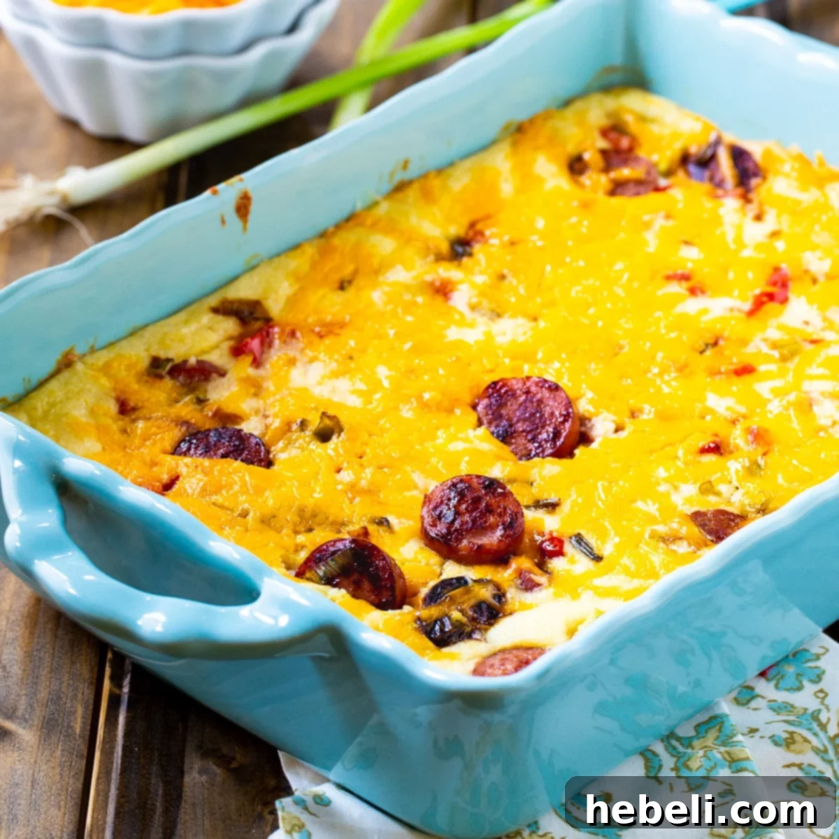 Close-up of a serving of Cheesy Grits Casserole with Smoked Sausage, showing the creamy texture and chunks of sausage and bell pepper.