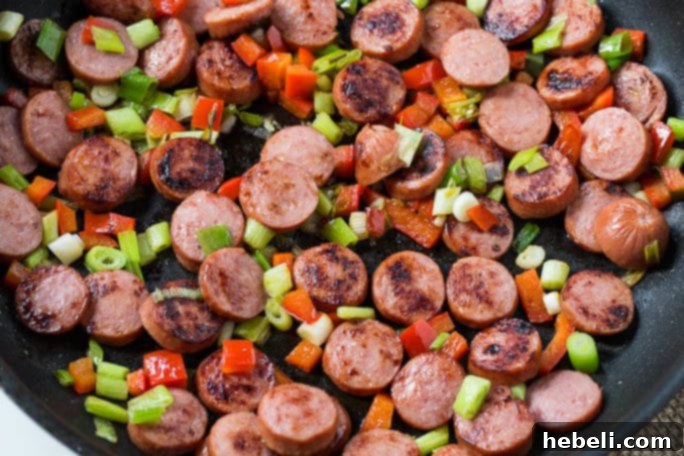 A large blue casserole dish filled with baked Cheesy Grits Casserole with Smoked Sausage, ready to be served.