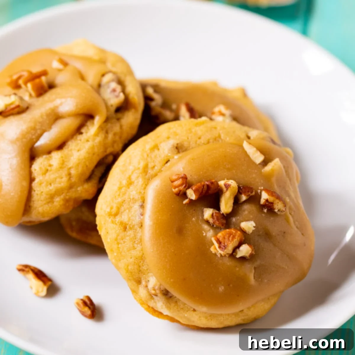 Plate of perfectly baked Caramel Frosted Brown Sugar Cookies with a rich caramel topping and chopped pecans.