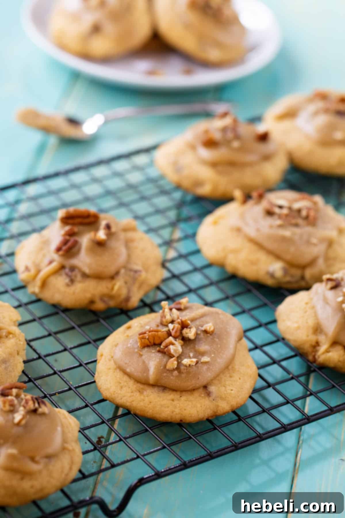 Freshly frosted Caramel Frosted Brown Sugar Cookies cooling on a wire rack.