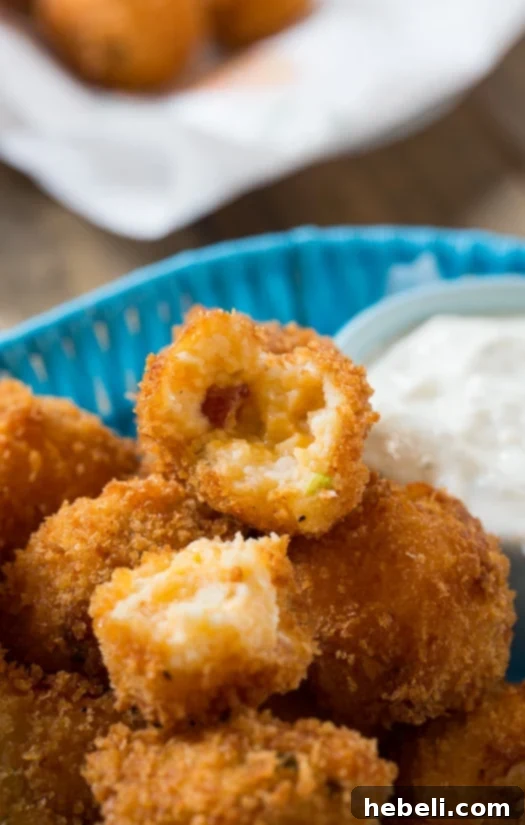 A plate of golden Fried Mashed Potato Balls with a side of creamy ranch dip.