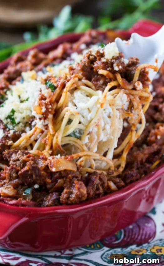 Spaghetti Beef Casserole with a decadent layer of cream cheese and a golden, buttery bread crumb topping, ready to be served from the dish.