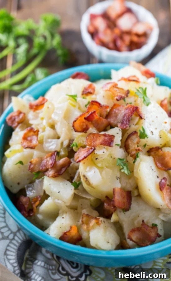 Hot Potato Salad generously topped with crispy bacon. This fantastic side dish boasts an irresistible combination of sweet, sour, and salty notes. Made with SPLENDA® for balanced sweetness. #SplendaSweeties #SweetSwaps #savory