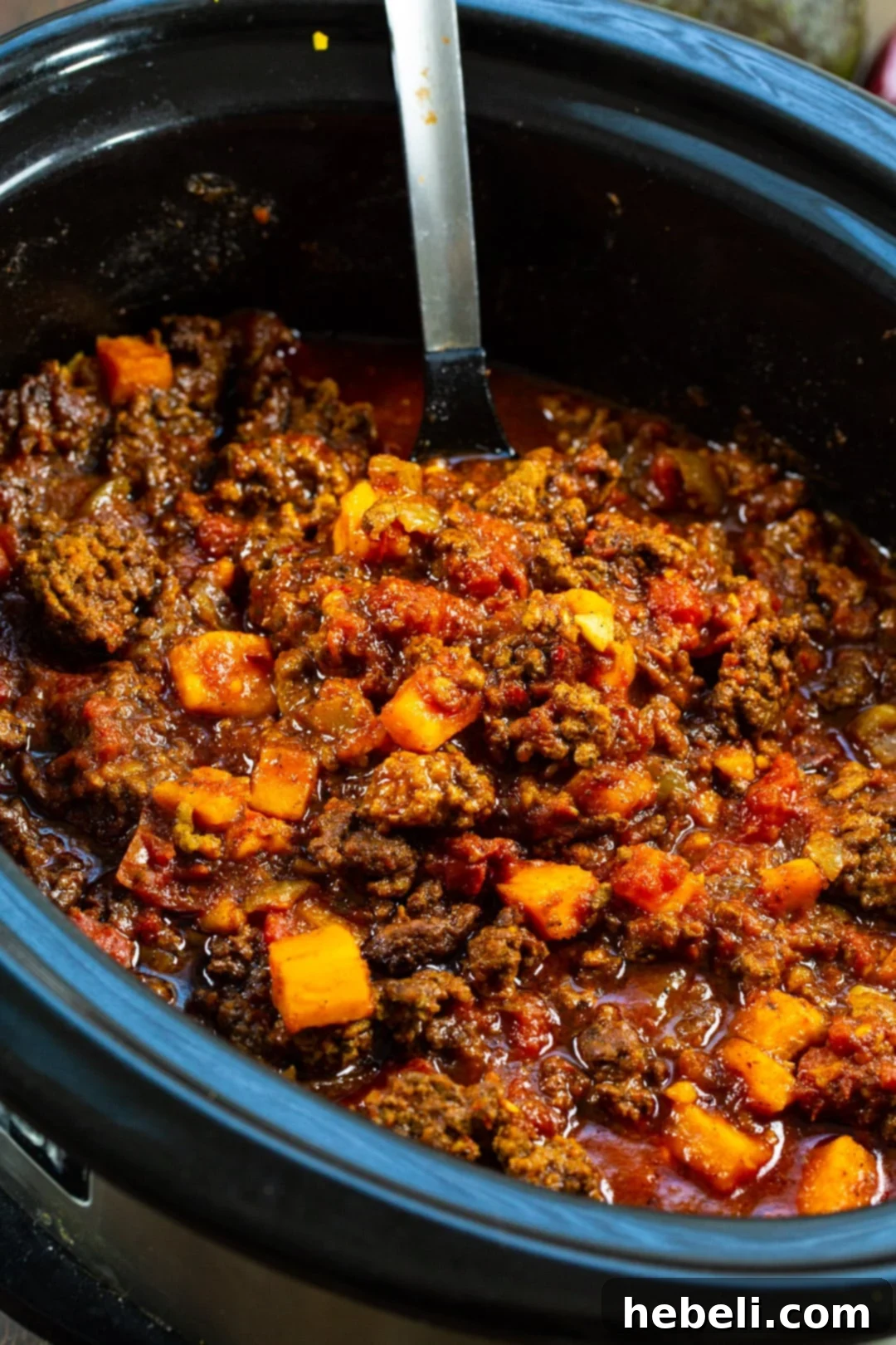 Rich beef and sweet potato chili simmering in a slow cooker, creating incredible aromas.