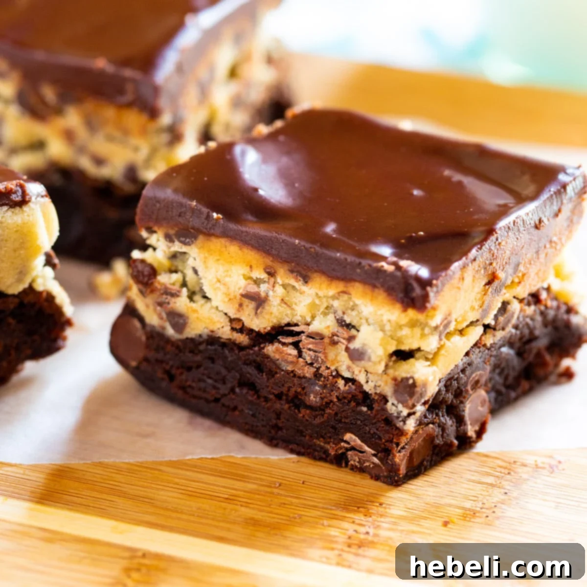 Decadent Cookie Dough Brownies displayed on a rustic wooden cutting board, showcasing their thick layers.