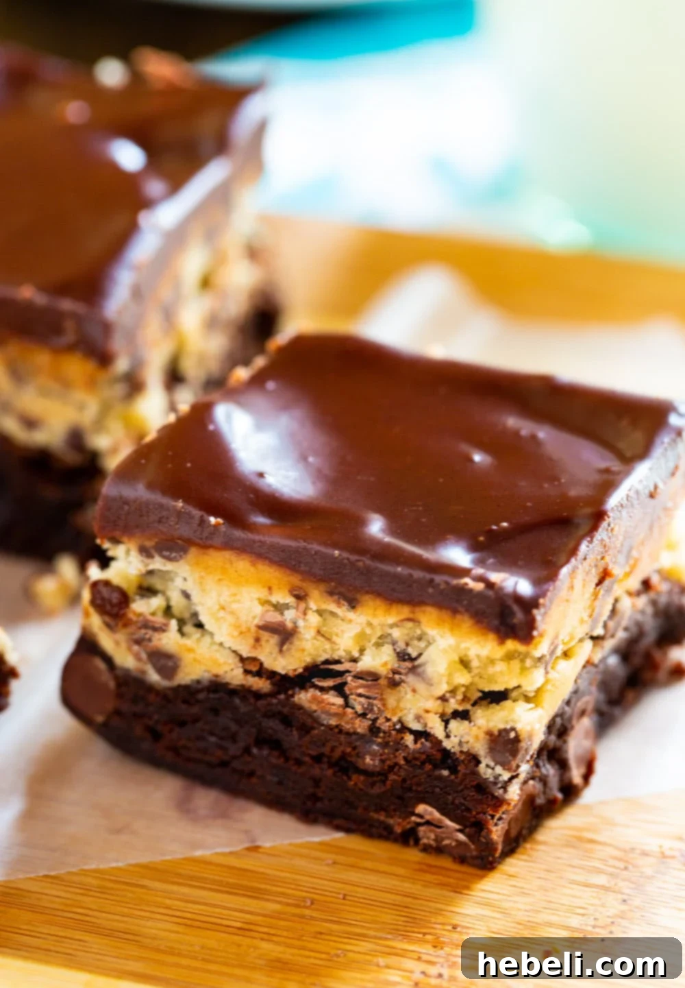 Close-up view of a slice of Cookie Dough Brownie, highlighting the distinct layers of brownie, cookie dough, and chocolate glaze.