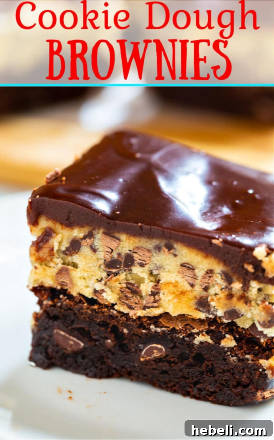 Stacked squares of Cookie Dough Brownies showing the distinct layers and glossy chocolate topping.