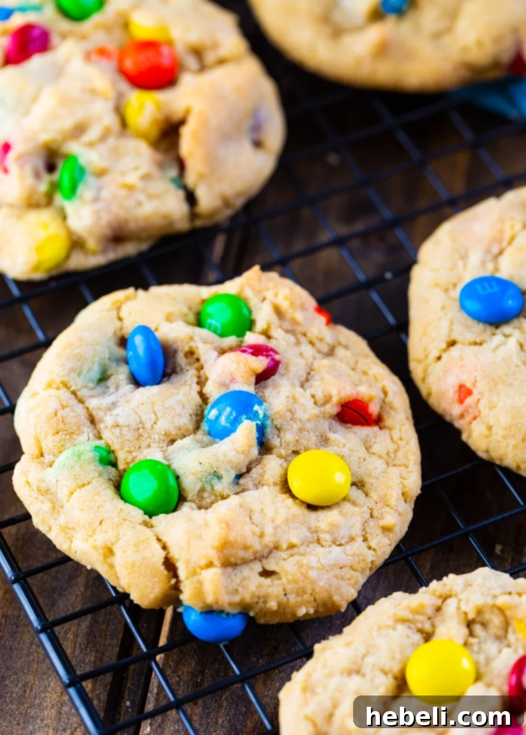 Perfect Soft & Chewy M&M Cookies 3 Freshly baked Soft and Chewy M&M Cookies cooling on a wire rack after coming out of the oven.