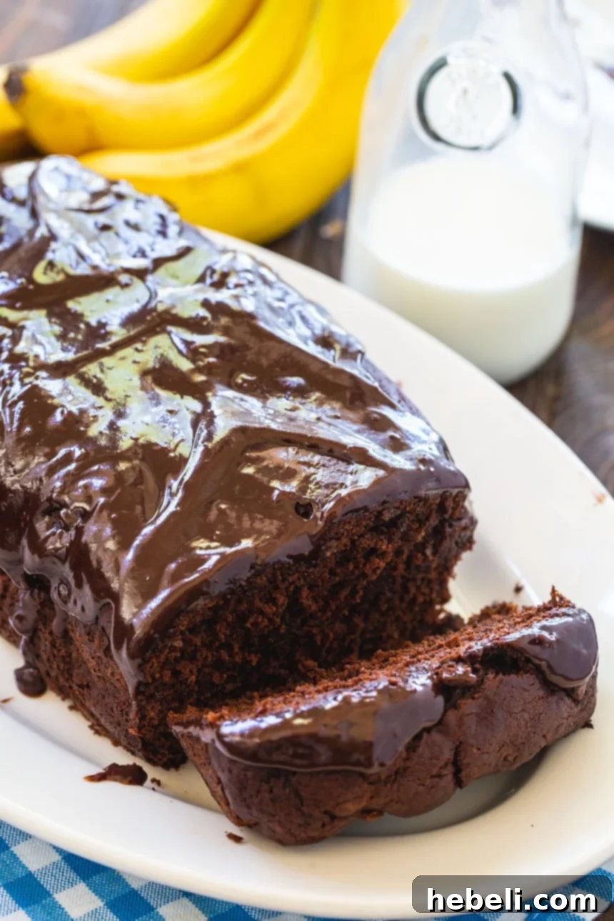 Decadent Triple Chocolate Banana Loaf 4 A beautifully presented Triple Chocolate Banana Bread loaf with a generous chocolate glaze on a pristine white serving platter.