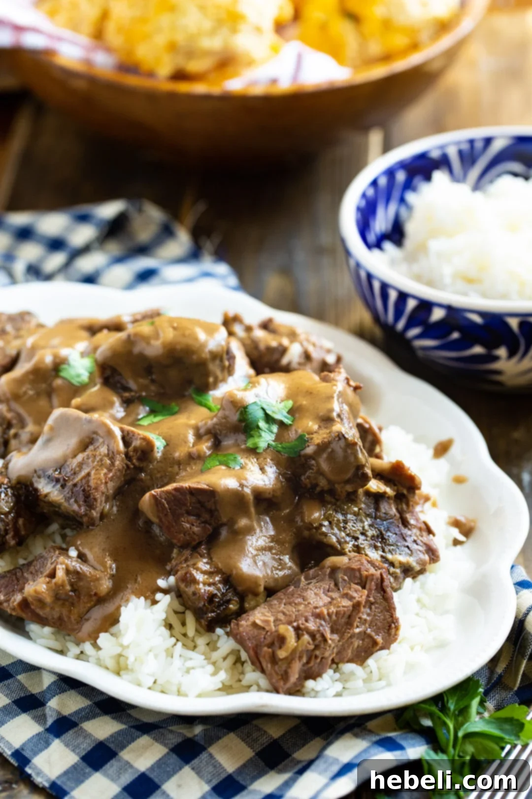 Generous serving of tender beef tips on a platter, with a separate bowl of white rice, ready to be served.