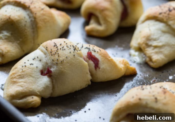 Stuffed Reuben Crescents 3 Close-up of baked Reuben Crescent Rolls, showing the golden crust and the delicious filling peeking out.