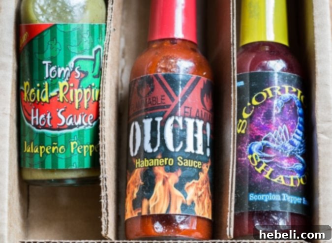 Cheesy Jalapeno Popper Crescent Rolls 4 A bottle of Tom's Roid Rippin Hot Sauce (Jalapeno Pepper) from The Monthly Pepper Box, featuring its distinctive green color and label.