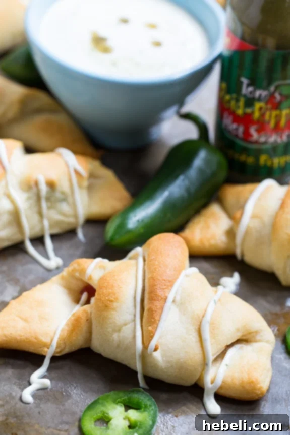 Cheesy Jalapeno Popper Crescent Rolls 8 Plate of golden Jalapeno Popper Crescent Rolls generously served with a bowl of homemade Spicy Ranch dipping sauce, ready to be enjoyed.