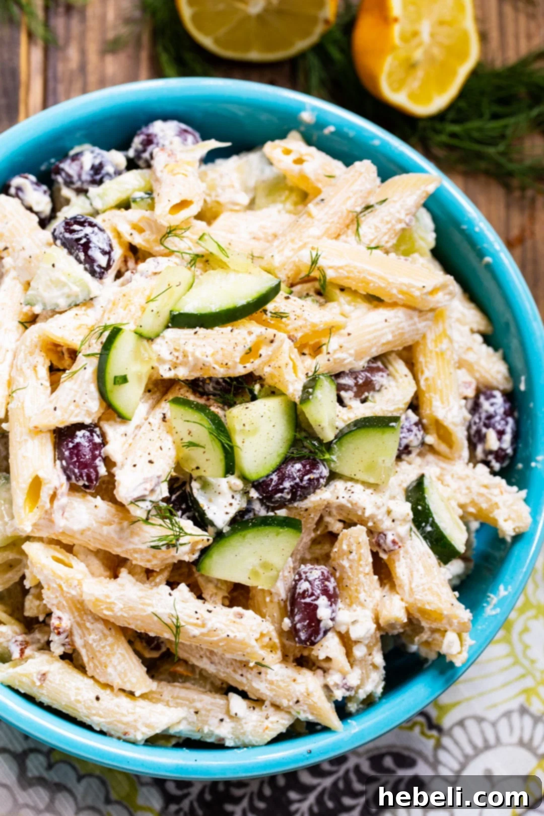 Close-up of Tzatziki Pasta Salad in a bright blue bowl, highlighting the creamy texture and fresh ingredients.