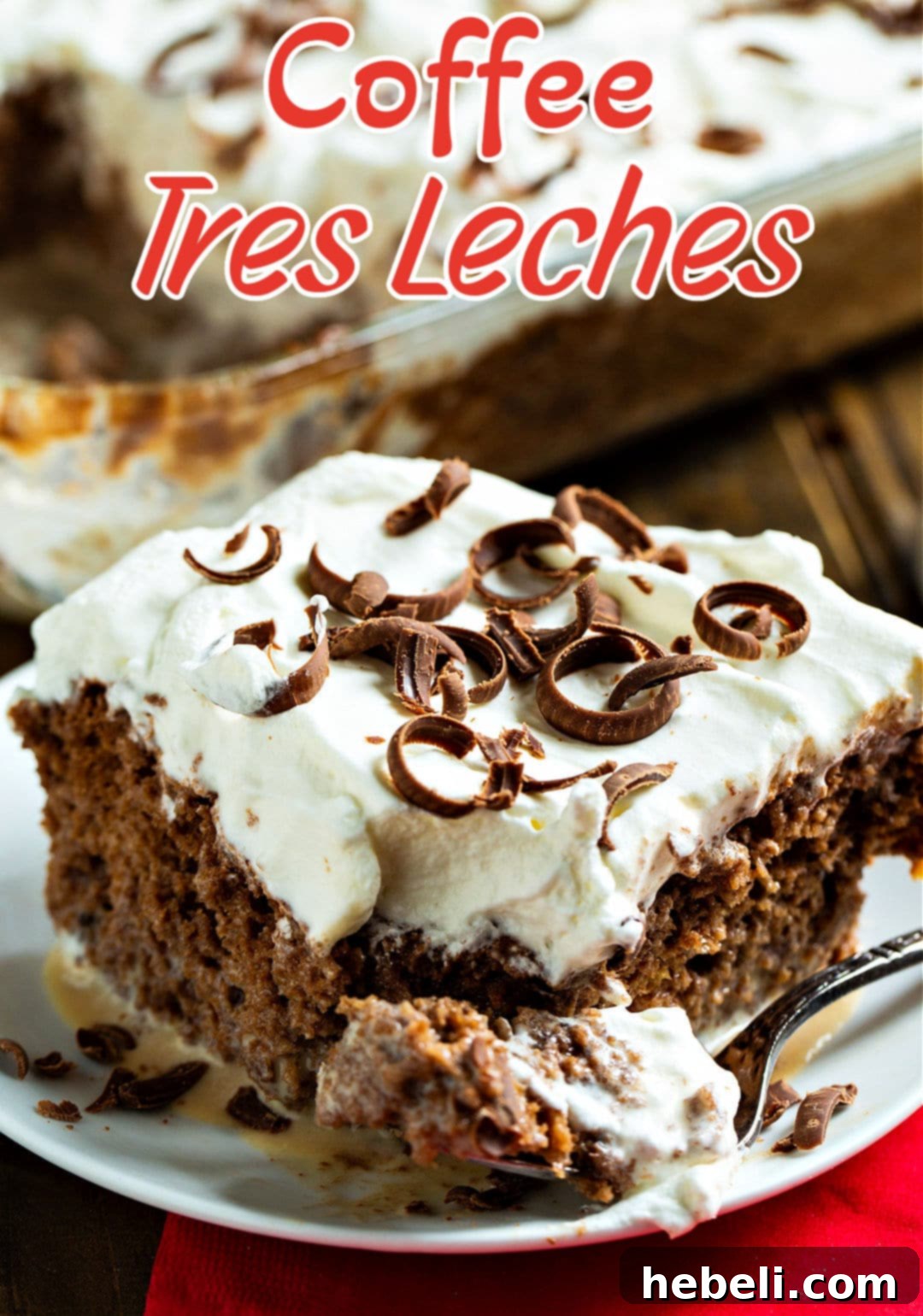 A fork taking a piece out of the Coffee Tres Leches Cake, showing its moist interior.