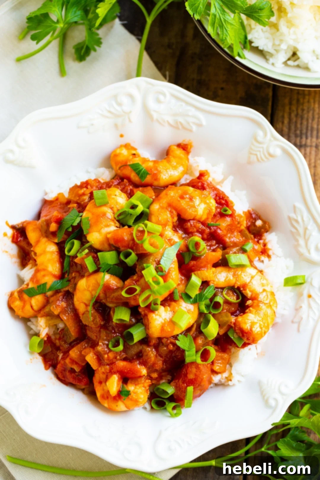 No-Fuss Shrimp Creole 3 Shrimp Creole served over rice in a deep bowl, garnished with green onions.