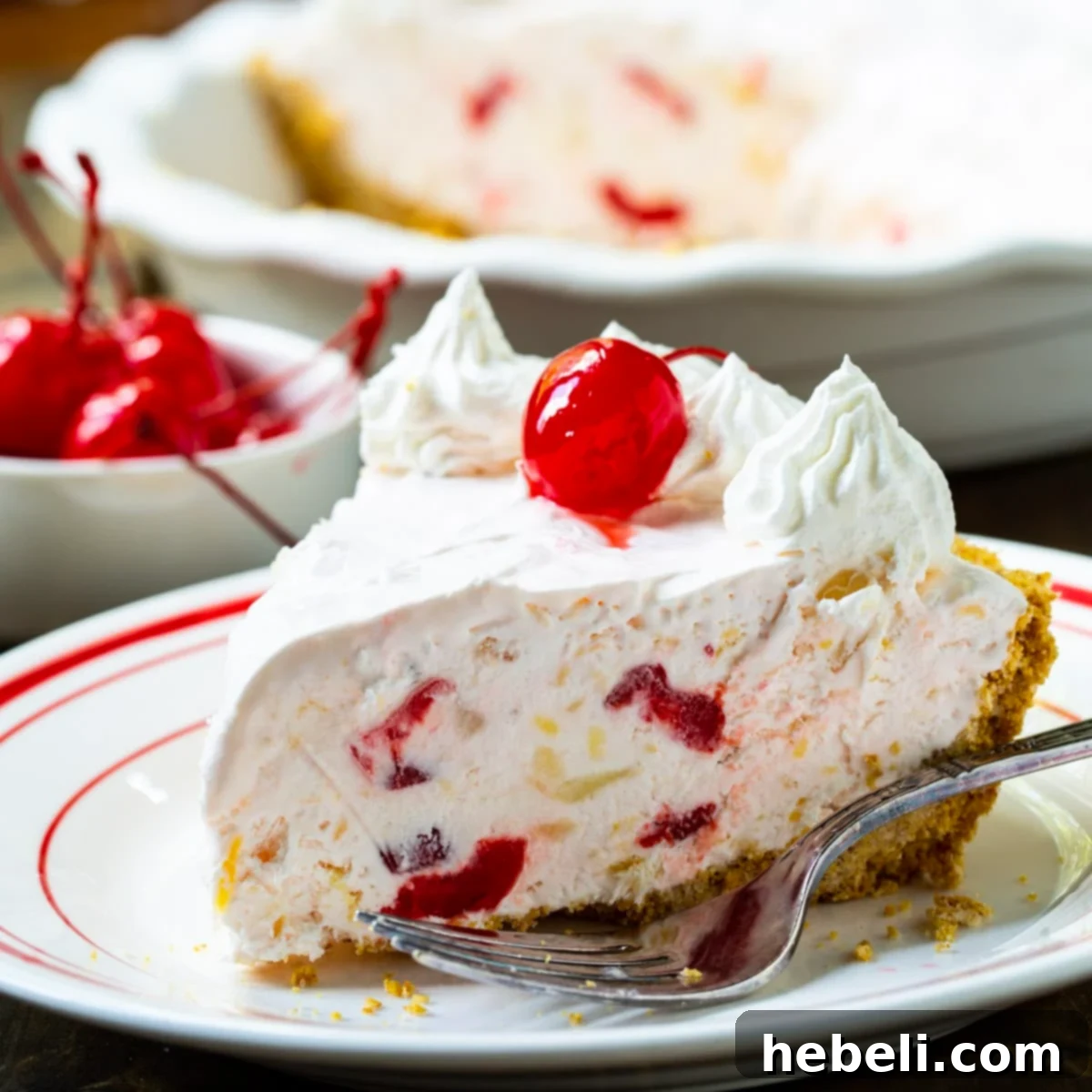 Ultimate No Fuss Millionaire Pie 2 A delectable slice of Retro Millionaire Pie, perfectly chilled and garnished with a bright red cherry, ready to be enjoyed.