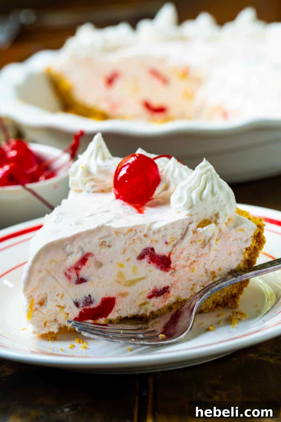 Ultimate No Fuss Millionaire Pie 3 A pristine slice of Millionaire Pie resting elegantly on a plate, showcasing its creamy texture and colorful mix-ins.