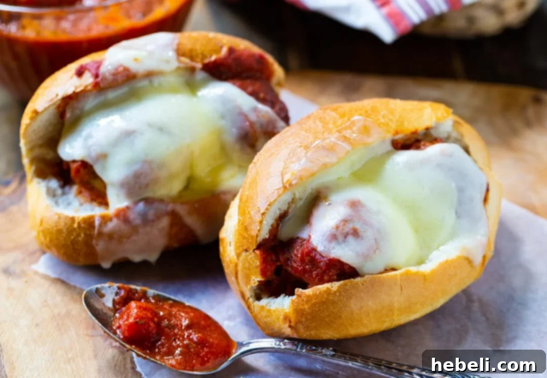 Two Slow Cooker Meatball Subs on a wooden board, garnished with parsley.