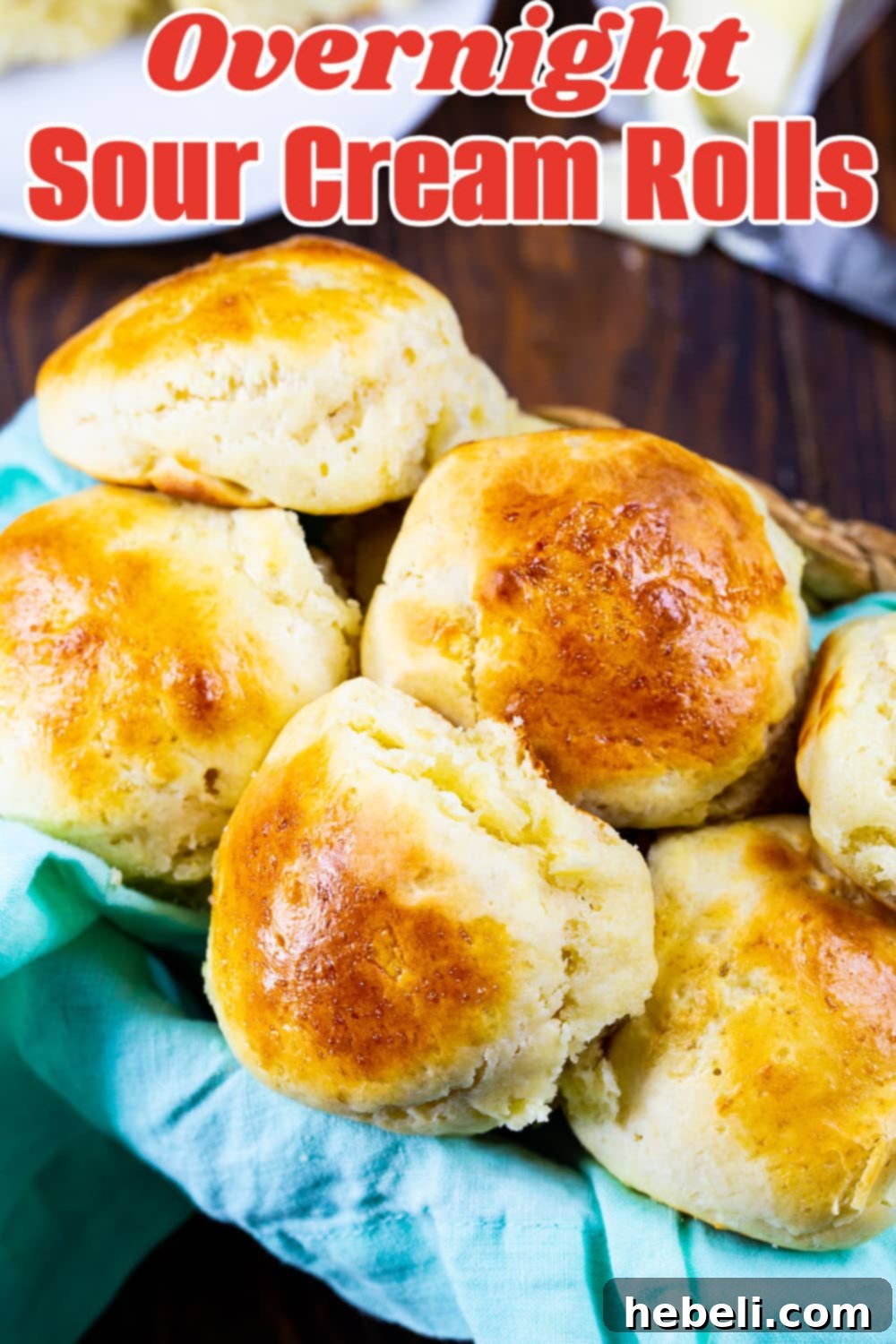 Pillowy Overnight Sour Cream Rolls 5 A charming close-up of Overnight Sour Cream Rolls nestled in a rustic bread basket, highlighting their inviting, homemade appeal.