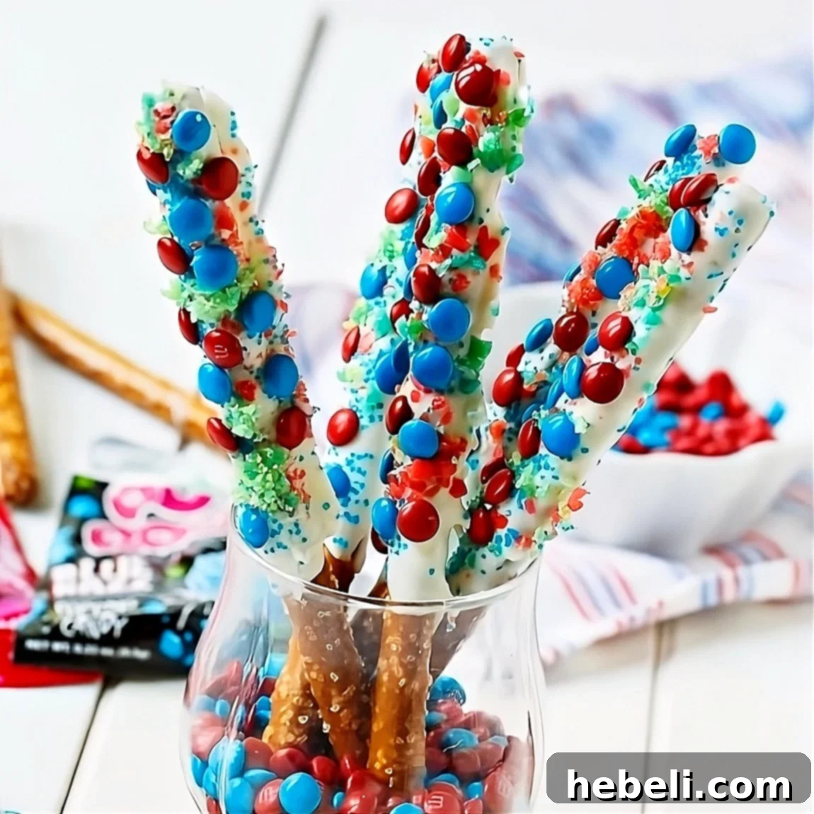 Flavor Burst Pretzel Rods 2 Vibrant Firecracker Pretzel Rods arranged upright in a glass, ready for a 4th of July celebration.