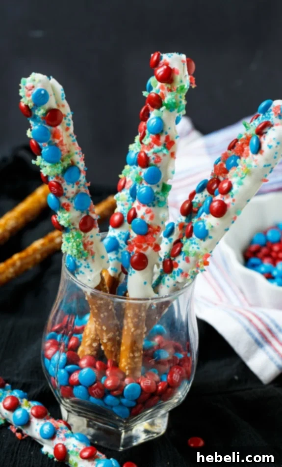 Flavor Burst Pretzel Rods 7 Close-up of Firecracker Pretzel Rods showcasing the vibrant red and blue mini M&Ms and shimmering Pop Rocks candy for a patriotic treat.