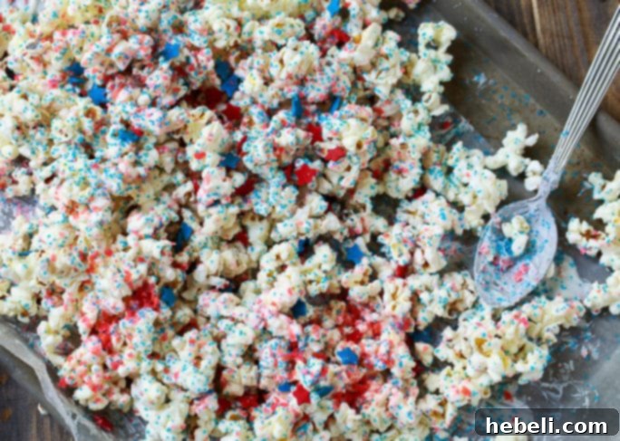 Close-up of Firecracker Popcorn for 4th of July, showcasing white chocolate coating and Pop Rocks candy.