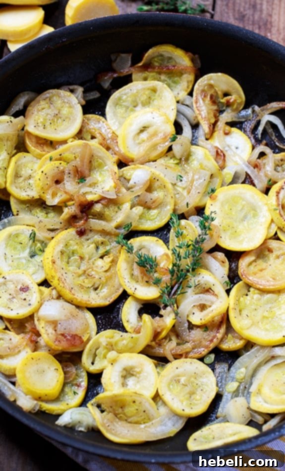Summer squash and onions sizzling in a cast-iron pan with bacon grease, developing a beautiful golden hue.