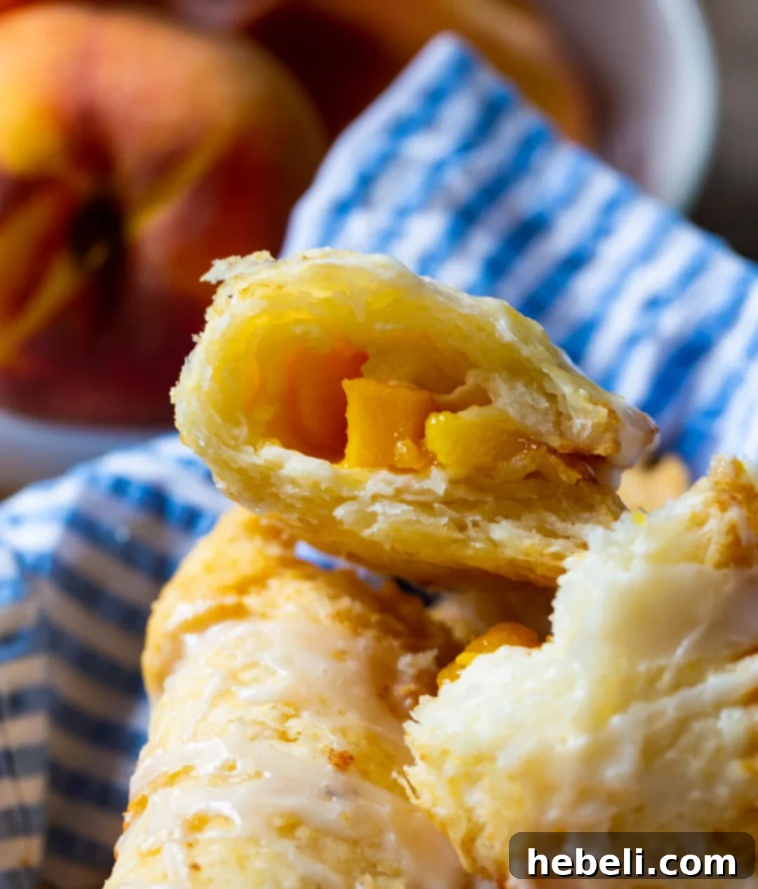 Golden Crispy Peach Turnovers 6 A freshly fried peach pie cut in half, revealing the succulent, chunky peach filling encased in a golden, flaky crust.