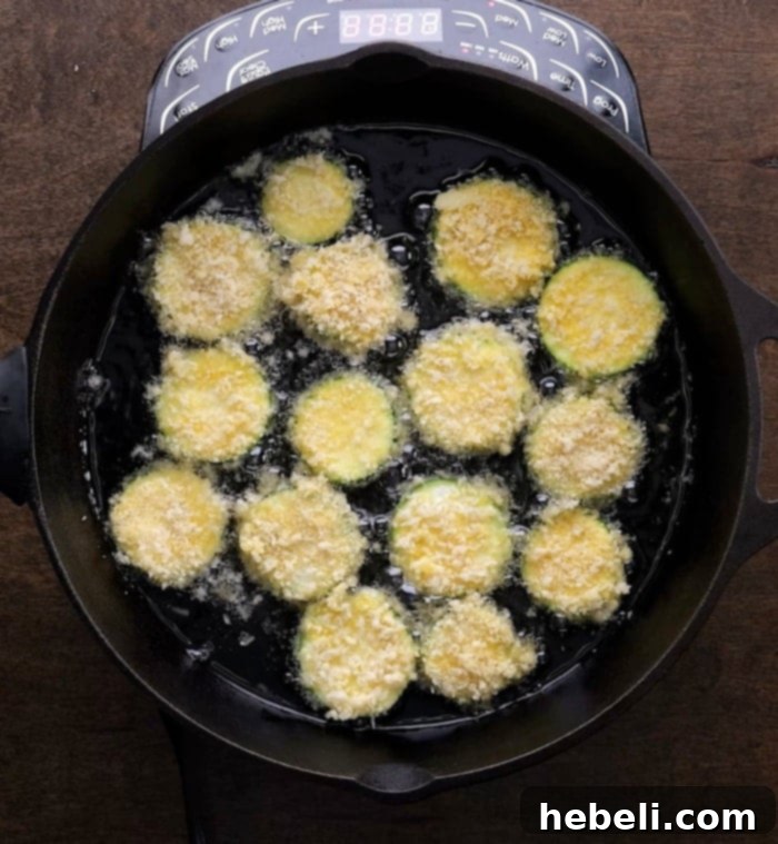 Golden Zucchini Crisps 6 Zucchini chips frying in hot oil until golden brown.