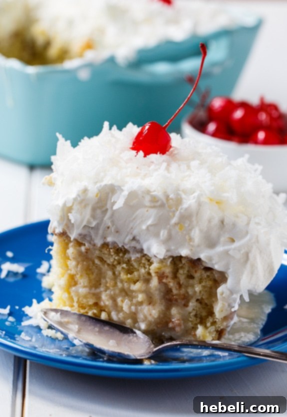 The Pina Colada Poke Cake after being poked and drenched in the creamy coconut and condensed milk mixture, ready for refrigeration.