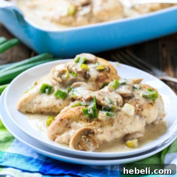 Close-up of golden-brown smothered chicken breasts in a rich, creamy mushroom sauce, garnished with fresh herbs, ready to be served family style.