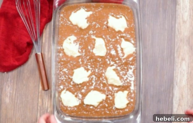 Dropping dollops of cream cheese mixture onto the cake batter