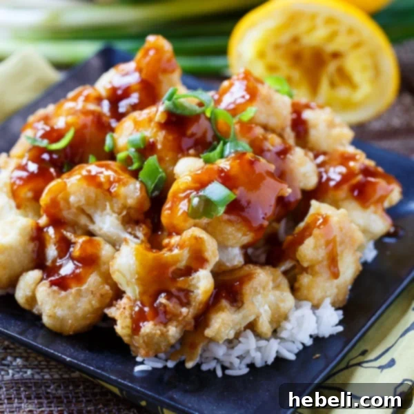 Vibrant Orange Cauliflower - a delicious vegetarian alternative to Orange Chicken, served with a garnish of green onions.