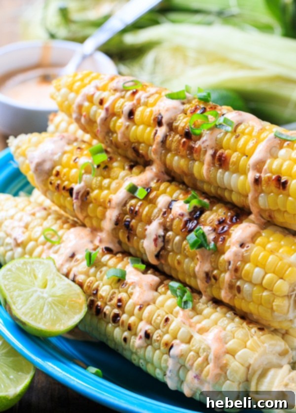 Smoky Grilled Corn with Creamy Chipotle 5 Several ears of grilled corn with chipotle cream, served on a rustic wooden board, ready for sharing.