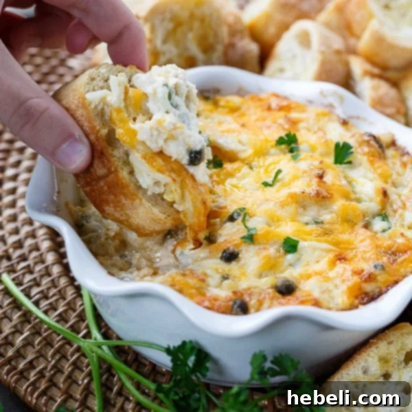 Hot Crab Dip - a creamy, cheesy seafood appetizer bubbling in a baking dish, served with crackers.
