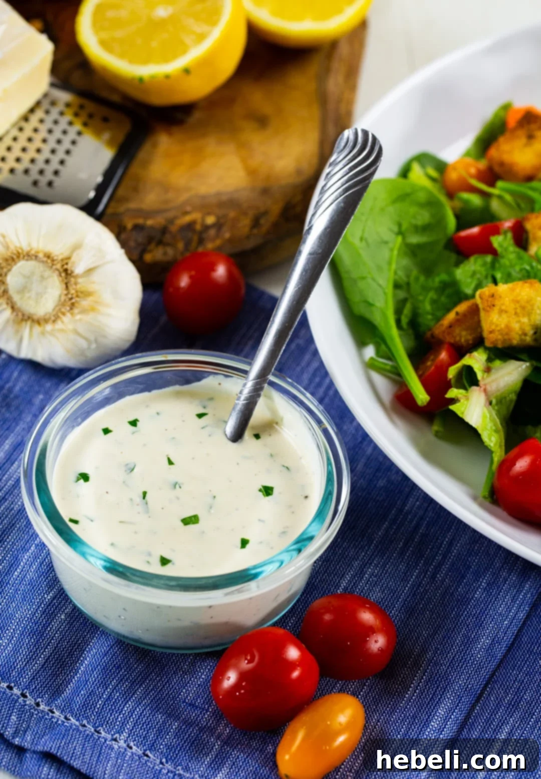 Carrabbas Style Creamy Parmesan Dressing 3 A spoon gently dipping into a bowl of rich, creamy parmesan dressing, highlighting its thick and inviting texture.