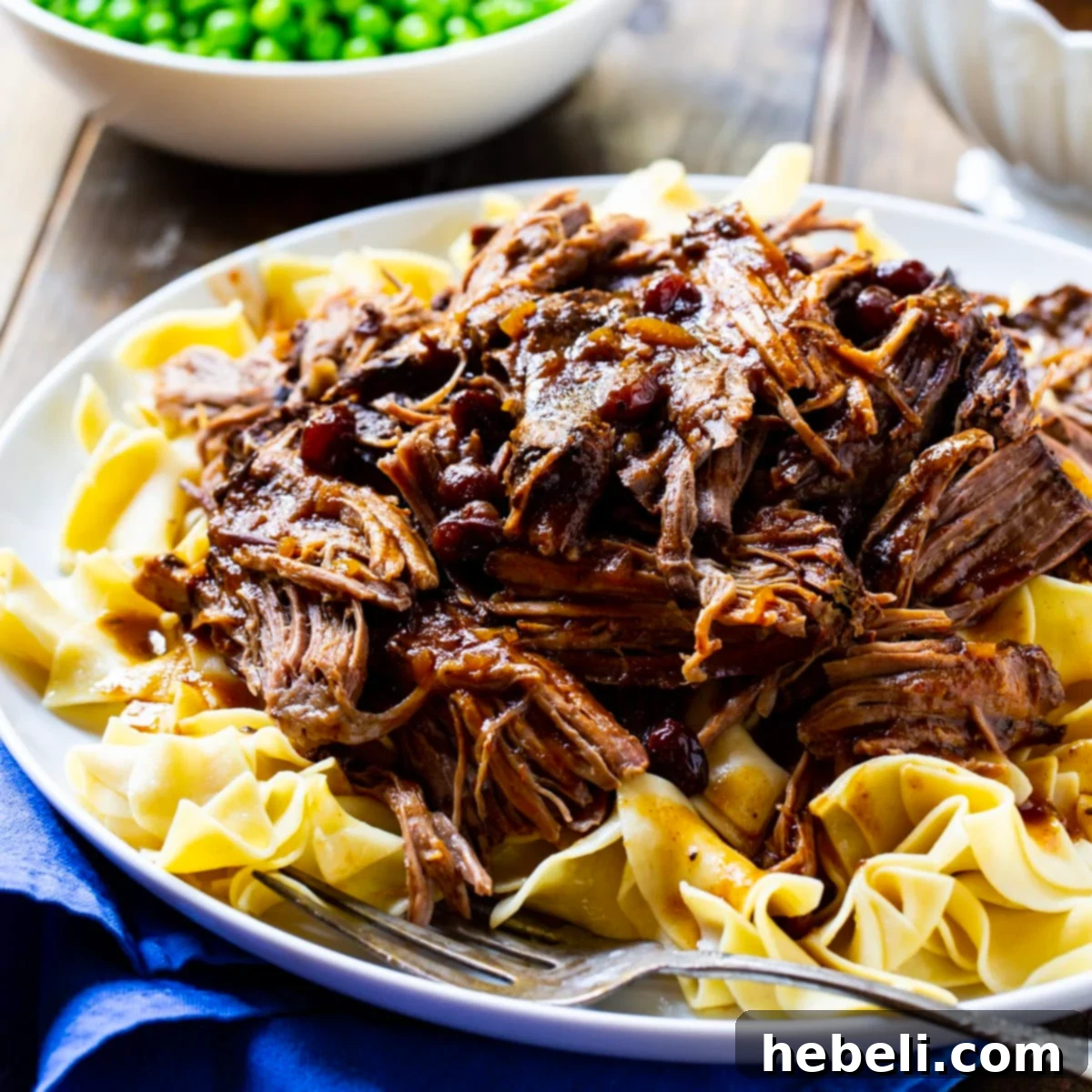 Crock Pot Pot Roast served over buttered noodles.